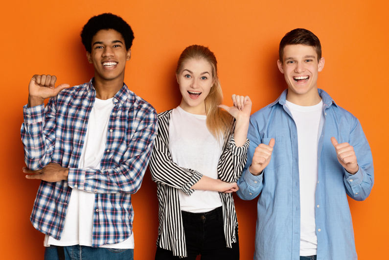 three persons smiling with a brown background
