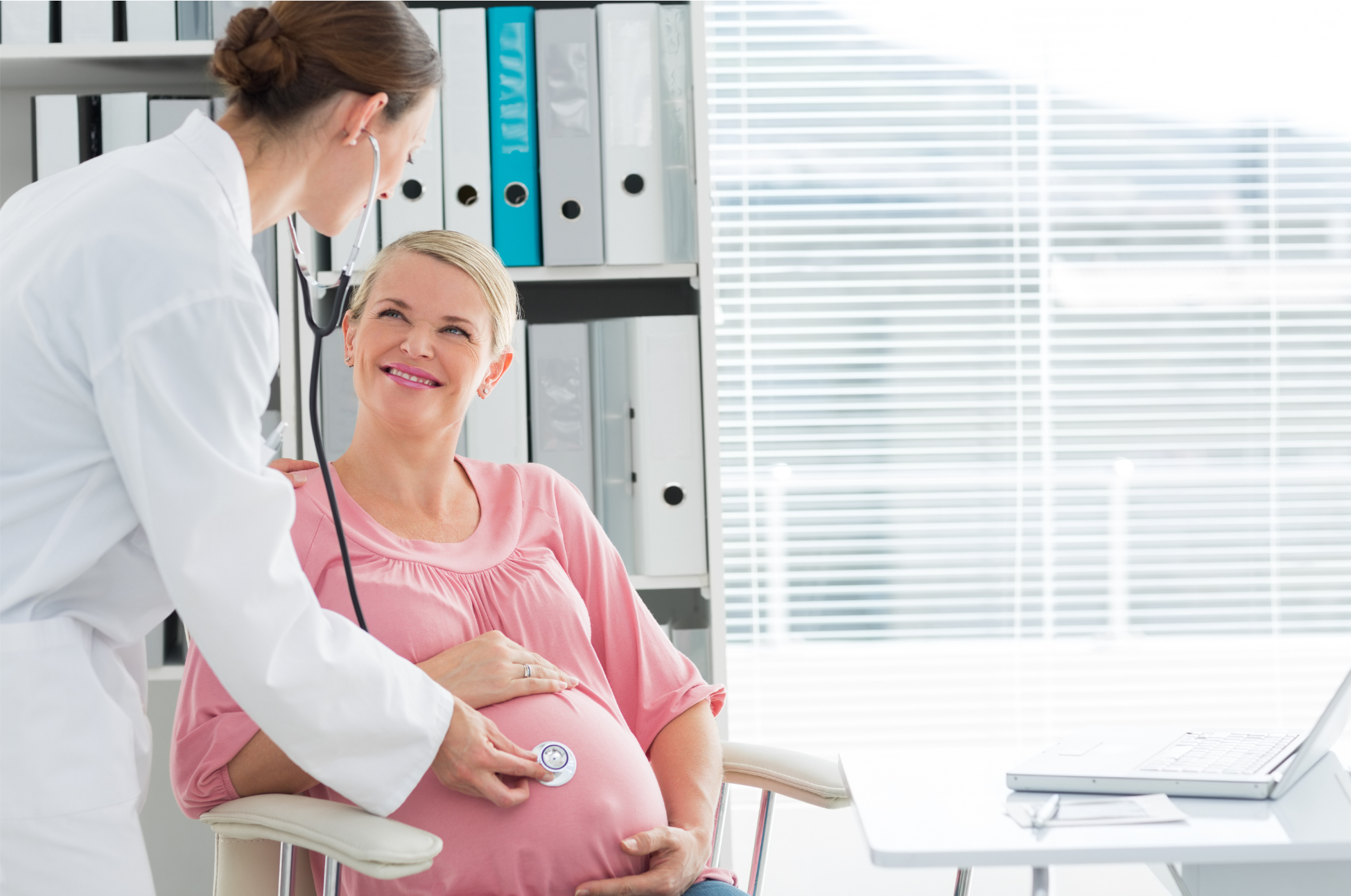 A Doctor and pregnant patient in a bright room