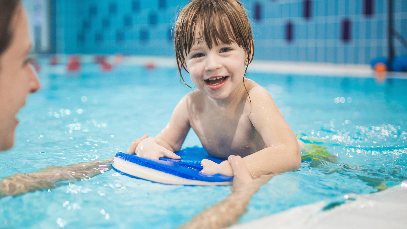Child swimming with parent
